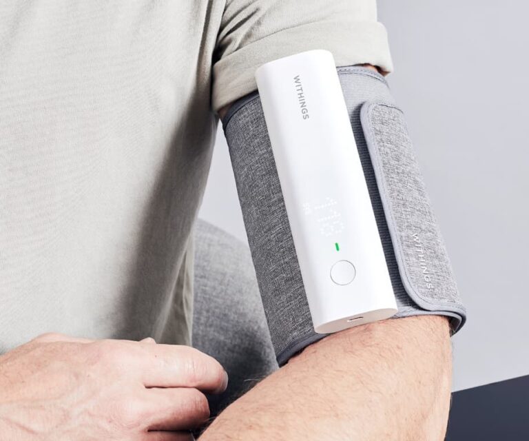 Persoon meet zijn bloeddruk met de Withings BPM Connect intelligente bloeddrukmeter met wifi om de bovenarm