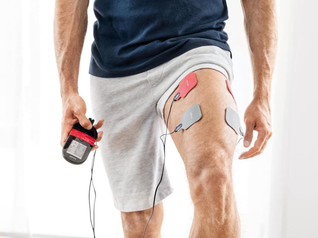 Beurer EM 59 EMS/TENS-apparaat met warmtetherapie met vier gelelektroden op een bovenbeen