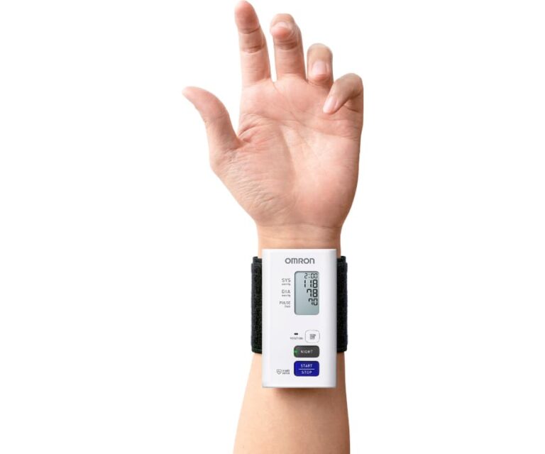 Close-up van een pols met de Omron Nightview polsbloeddrukmeter om