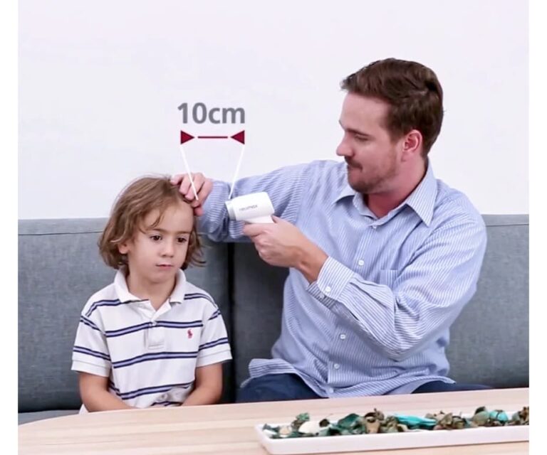 Man meet de voorhoofdtemperatuur van een kind met de Rossmax HC700 BT contactloze thermometer met een afstandslijn en de tekst “10cm” in beeld