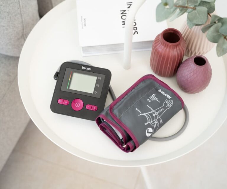 Beurer BM 27 Limited Edition zwart/roze bovenarm bloeddrukmeter met manchet op een tafeltje