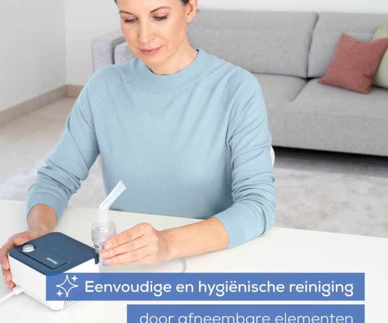 Vrouw aan tafel houdt de Beurer IH 16 vast met het mondstuk eraan bevestigd