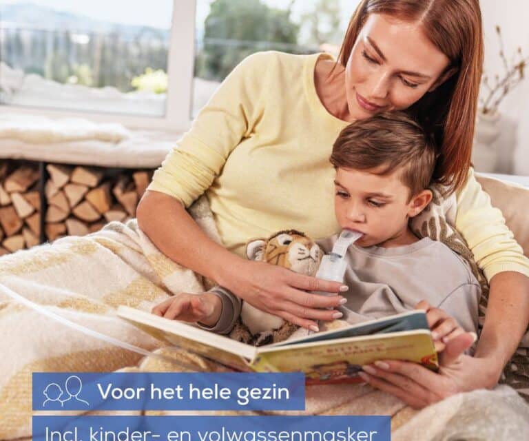 Vrouw en kind zitten op de bank met een knuffel en een kinderboek, terwijl het kind vernevelt met het mondstuk van de Beurer IH 28 Pro in de mond